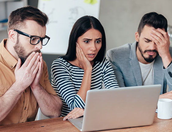 Trabajadores sorprendidos y preocupados mientras miran un ordenador