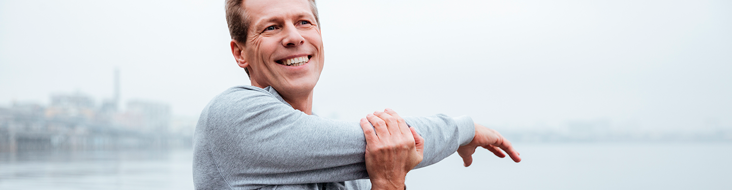 Hombre sonriendo estirando en la calle