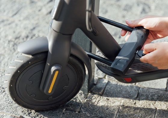 Persona poniendo un candado con llave en el patinete eléctrico